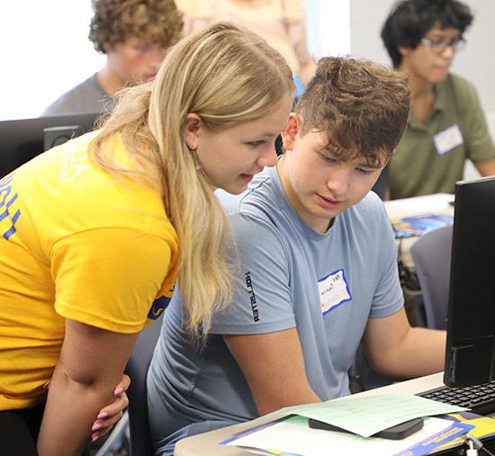 Student receiving personal assistance at a computer lab station